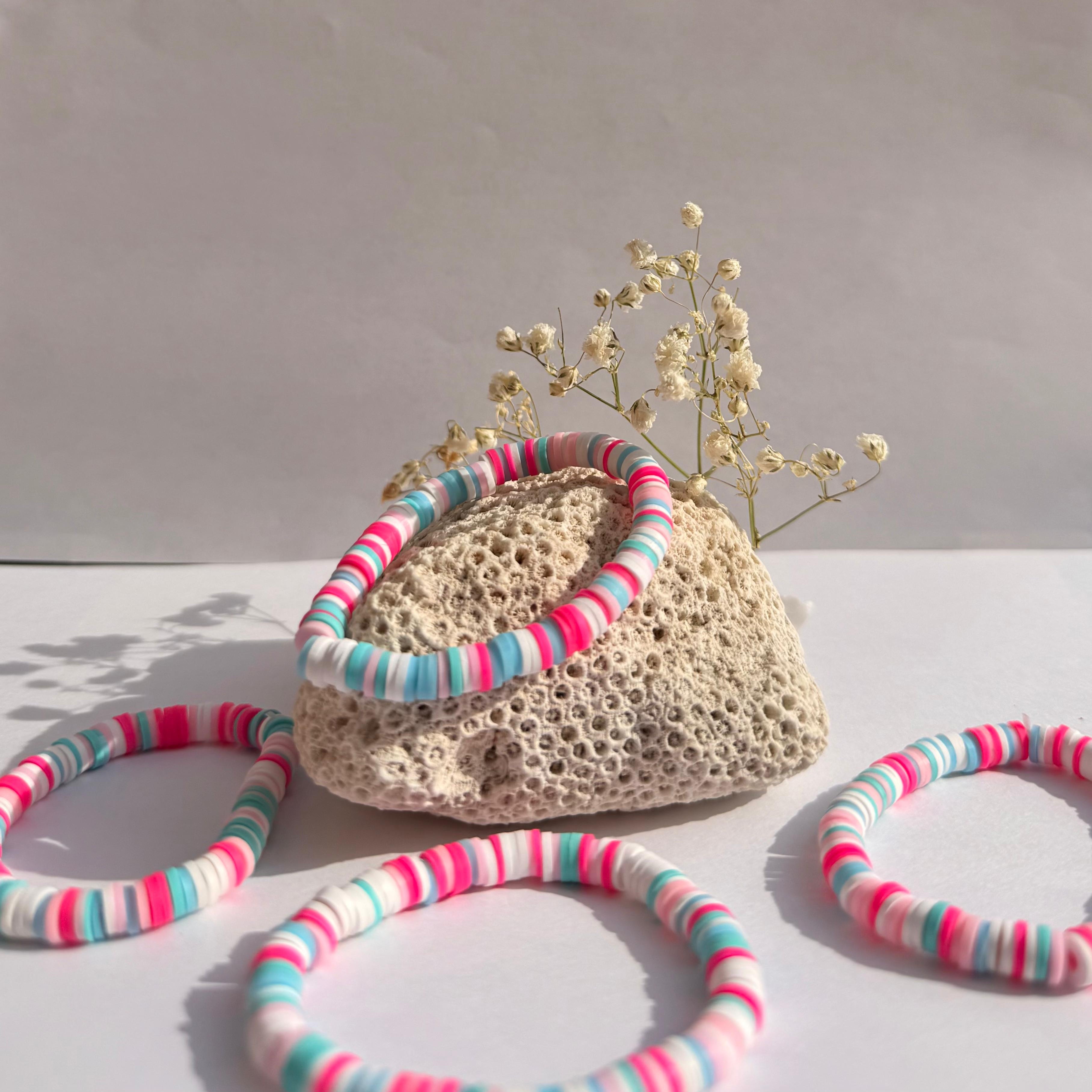 Bubblegum Party bracelets around a rock with dried flowers against a white background