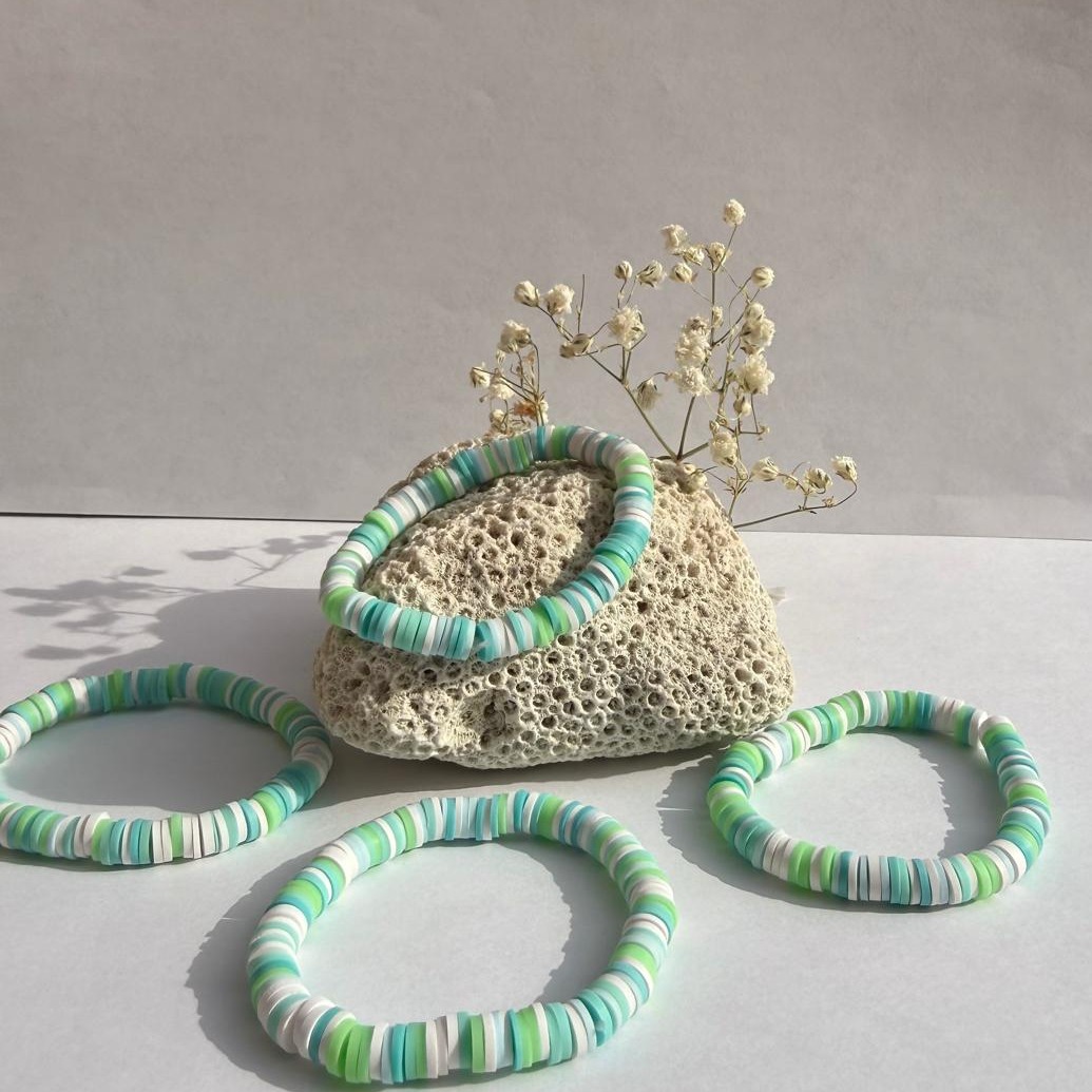 Turquoise Tide bracelets arranged around a rock with flowers