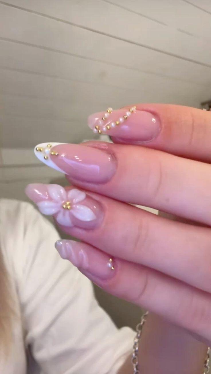 Medium design inspiration with white French tips, pearls, gems, and 3D flower accent